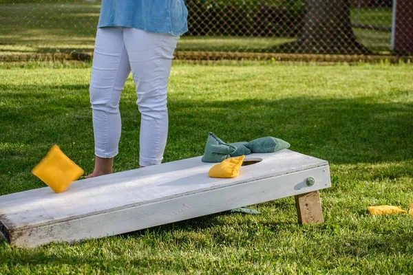 Jeune femme jouer sacs jeu en été — Photo