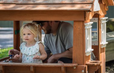 Baba oyun evinde çocuklarıyla oynuyor.