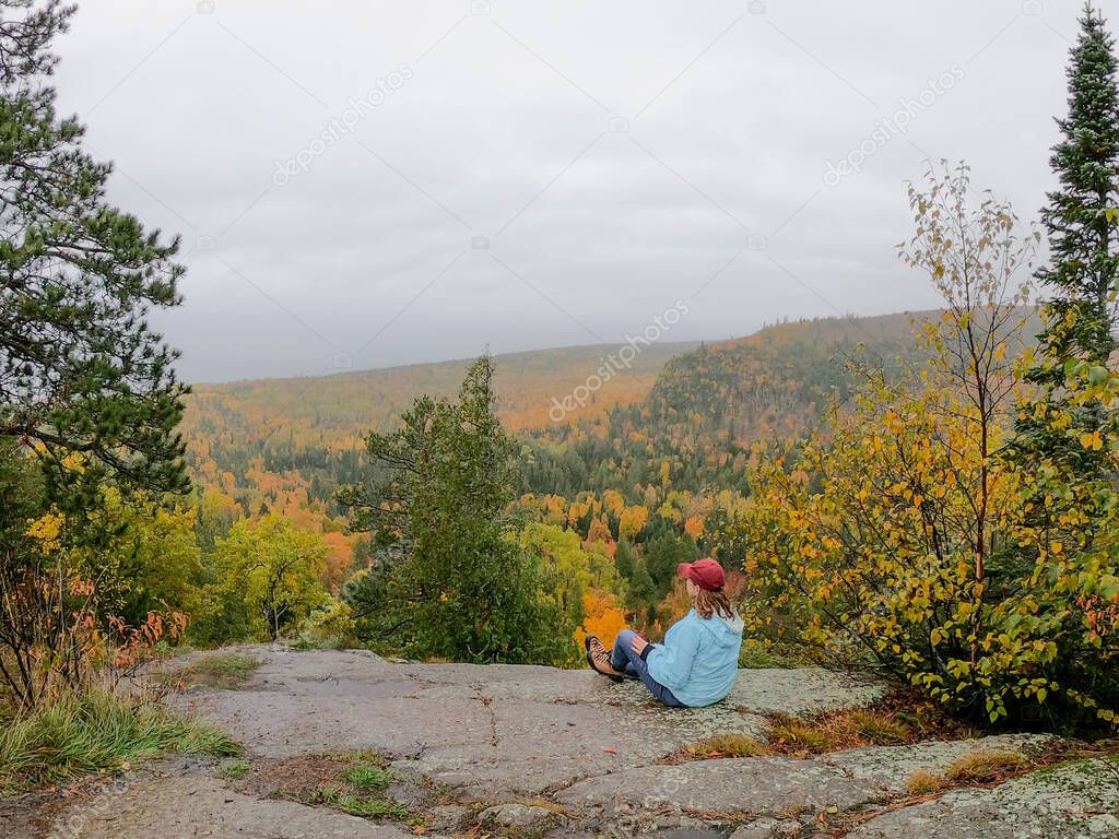 woman looking out at beautiful fall colors from top of Oberg Mountain in Minnesota