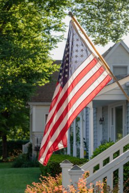 Barrington, IL 'deki ana caddede güneş ışığıyla dalgalanan Amerikan bayrağı.