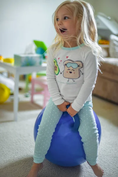 happy child playing on bouncy ball in pajamas