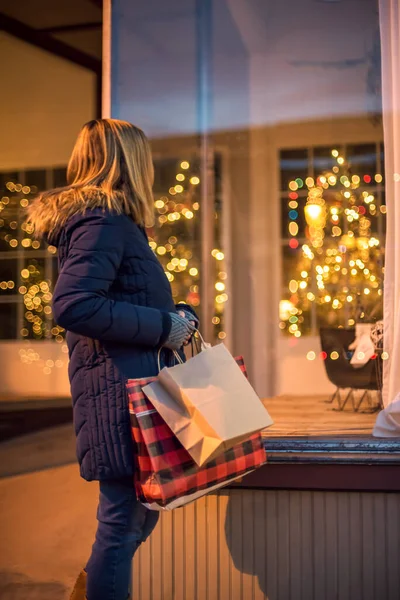 Γυναίκα Χριστουγεννιάτικα Ψώνια Μεταφέρουν Τσάντες Ψώνια Ψάχνει Στο Παράθυρο Του Εικόνα Αρχείου