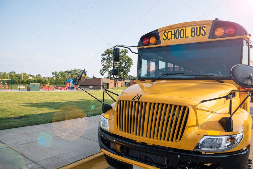 yellow school bus parked in front of school playground