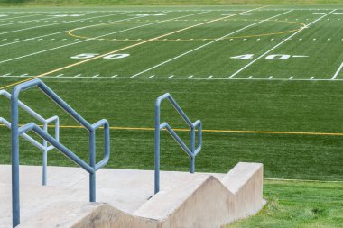 view of 50 yard line of high school football field from the stands clipart