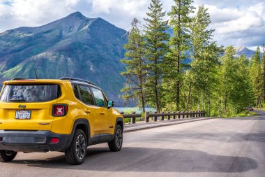 Batı Buzulu, Montana ABD 18 Temmuz 2019: Sarı Jeep, Buzul Ulusal Parkı 'ndaki Güneşe Gidiş yolu boyunca park etmiş.