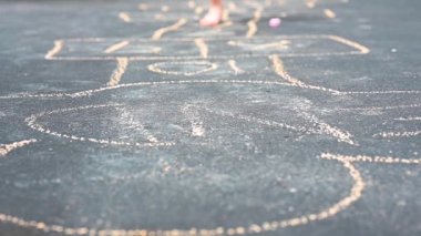 Kaldırımda ağır çekimde seksek oynayan küçük kız