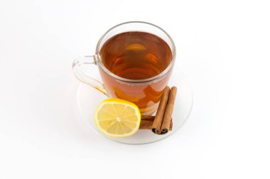 Çay bardağı limon ve beyaz arka plan üzerinde izole tarçın.