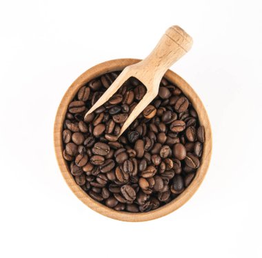 Kahve çekirdekleri beyaz zemin üzerine bir kepçe ile bir ahşap kase.