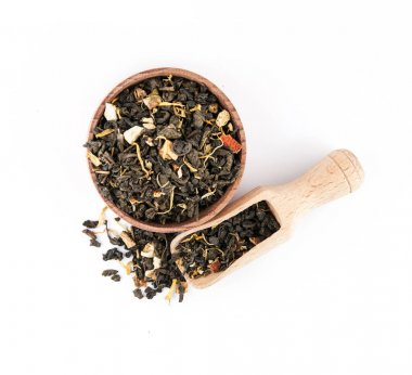 Beyaz bir arka plan üzerinde ahşap bir kasede yeşil meyve çayı.