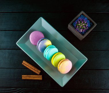 Lezzetli ve renkli bademli kurabiye plaka. Tarçın bir siyah ahşap dokulu masada parçaları.