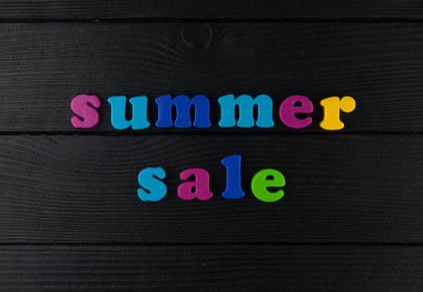 Satılık Plastik harfler siyah deri arka plan üzerinde.