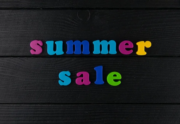 Sale plastic letters on a black leather background.