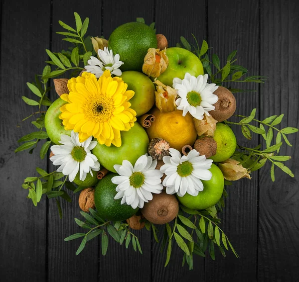 Fruit bouquet  with apples, yellow flowers, kiwi fruit and avocado.