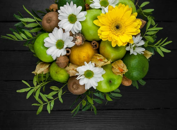 Fruit bouquet  with apples, yellow flowers, kiwi fruit and avocado.