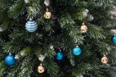 Toplarla, süslemelerle ve ışıklarla süslenmiş yapay Noel ağacı. Terfi için şenlik arka planı.