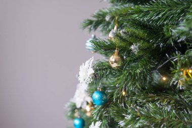 Toplarla, süslemelerle ve ışıklarla süslenmiş yapay Noel ağacı. Terfi için şenlik arka planı.