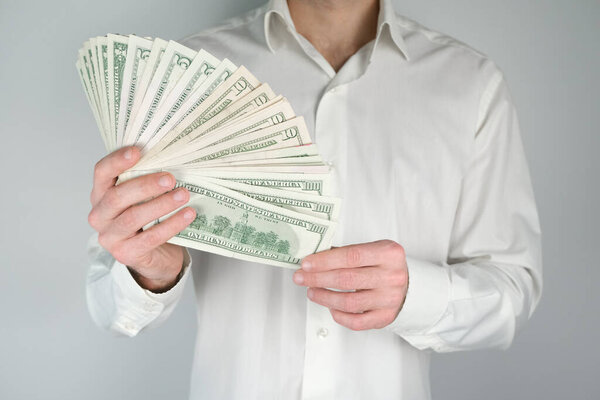 Деловой человек считает деньги в своих руках. Концепция богатства, богатой жизни, зарабатывания денег в Интернете
.