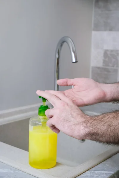 Man uses  a liquid soap. Concept of daily routing, washing hands, soap and water, hygiene cleanliness.