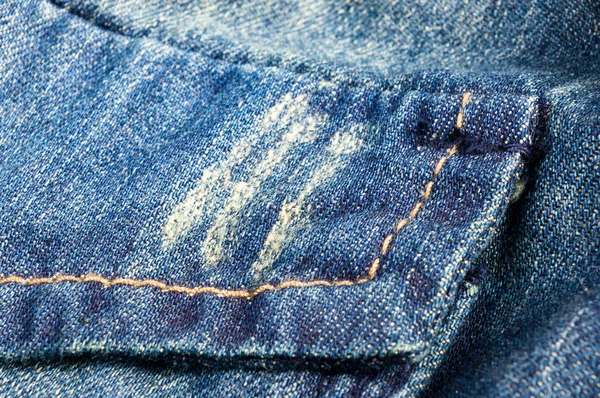 clothing items blue stonewashed faded jeans cotton fabric texture with seams, clasps, buttons and rivets, macro, close-up