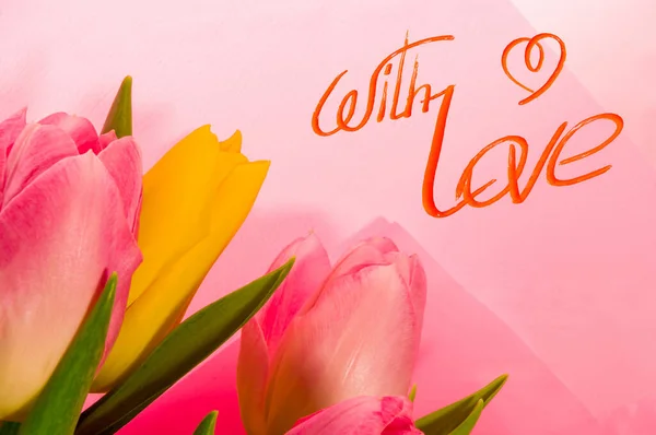 Greeting card - a bouquet of fresh spring pink and yellow tulips, holiday greetings, handwritten inscription with a brush, greeting lettering.