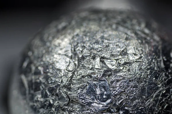 Unusual abstract techno view of crumpled aluminum foil ball, close-up, macro photo