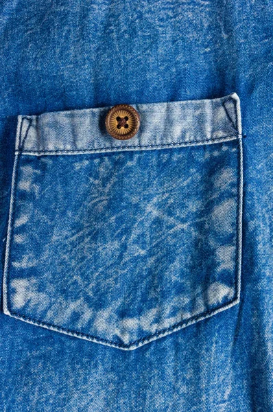 clothing items blue washed faded jeans cotton fabric texture with seams, clasps, buttons and rivets, macro