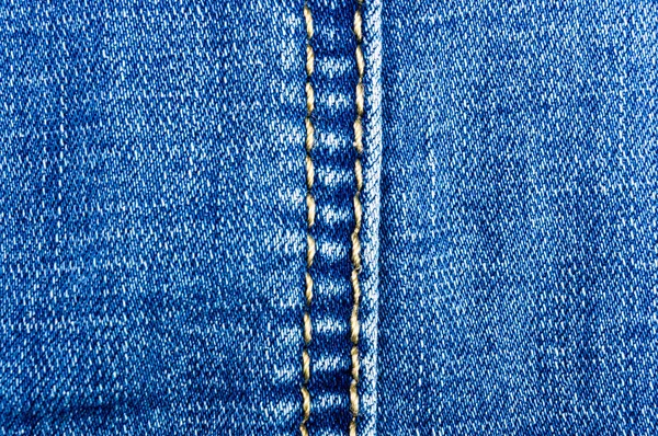 clothing items blue washed faded jeans cotton fabric texture with seams, clasps, buttons and rivets, macro