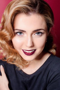 Kırmızı dudaklar kırmızı bir sandalyede oturan bir kırmızı zemin üzerine siyah elbiseli güzel kız