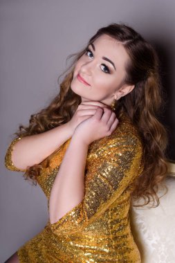 gri bir arka plan üzerinde kız takı gösterir