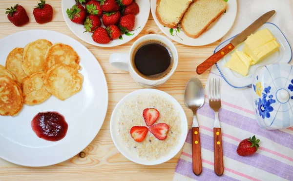 Frühstück .Haferbrei, Pfannkuchen mit Marmelade, Butter, Kaffee und Erdbeere. — Stockfoto