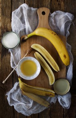 Muz ve bal bir kesme tahtası üzerinde.