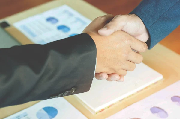 Twee zakenmannen schudden handen met documentachtergrond — Stockfoto