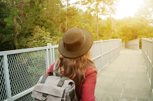 Mulher viajante com mochila e chapéu andando em passarela incrível — Fotografia de Stock