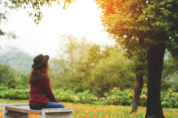 Doğa arka plan ile bankta oturan kadın