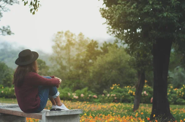 Vrouw reiziger zitten en zie zonlicht met groene natuur achtergrond — Stockfoto