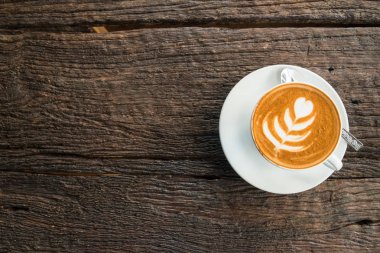 Sıcak latte üzerinde ahşap masa kahve bir fincan.