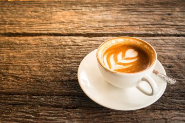 Sıcak latte üzerinde ahşap masa kahve bir fincan.