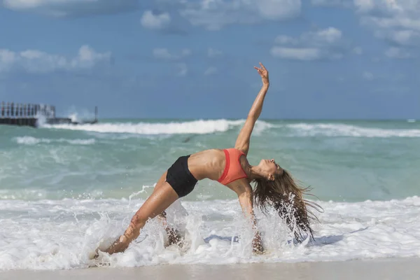 Atleta donna che fa yoga sulla spiaggia — Foto Stock