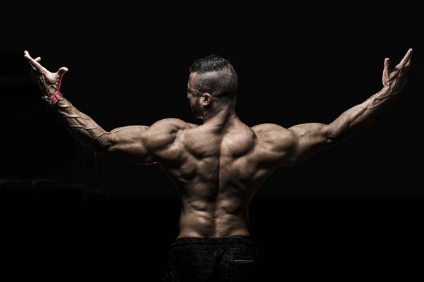 Homem mostrando muscular de costas com os braços bem abertos — Fotografia de Stock