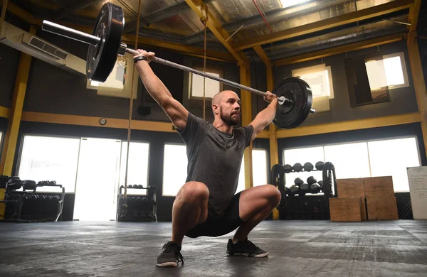 Sterke crossfit atletische tillen van zware gewichten in sportschool vak — Stockfoto