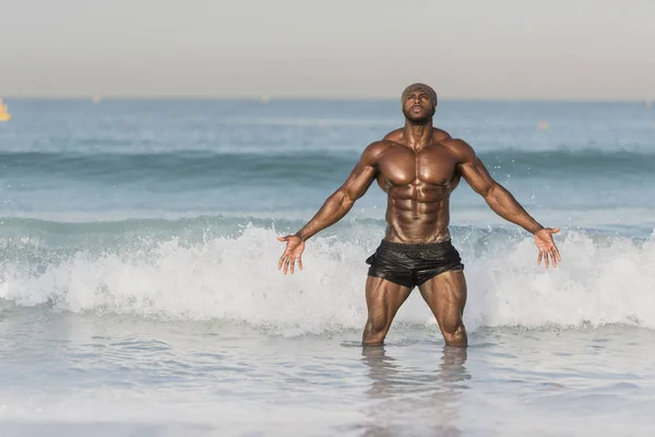 Чоловік стоїть у воді на краю пляжу — стокове фото