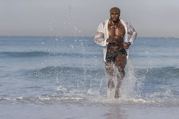 Человек бежит по краю пляжа — стоковое фото