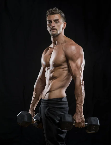 Muskulöser Bodybuilder mit Kurzhanteln — Stockfoto