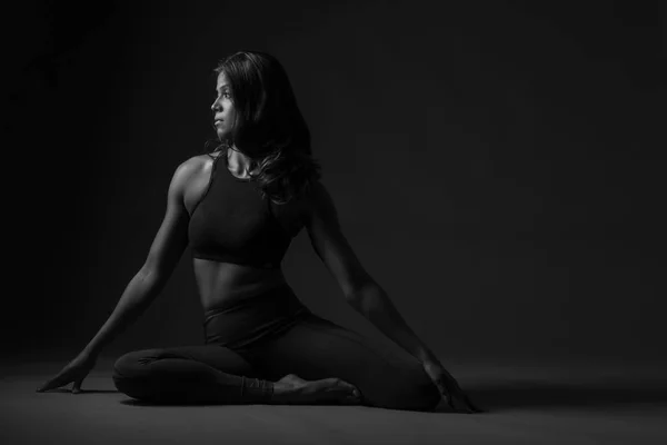 Beautiful Indian woman sitting pigeon yoga pose in b & w — стоковое фото
