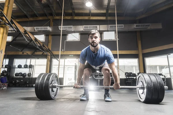 Athlete in process of lifting barbell — Stock Photo, Image