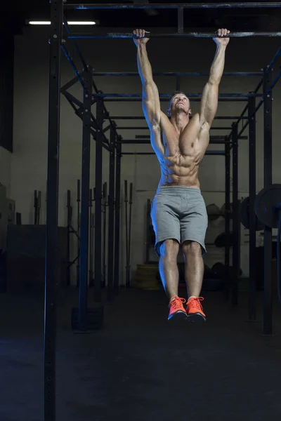 Muscular branco caucasiano homem fazendo pé a barra ou perna elevadores exercício — Fotografia de Stock
