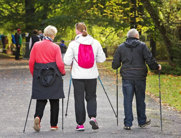 Drie mensen in het park - Nordic walking — Stockfoto