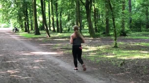 年轻女性慢跑者戴着耳机 — 图库视频影像