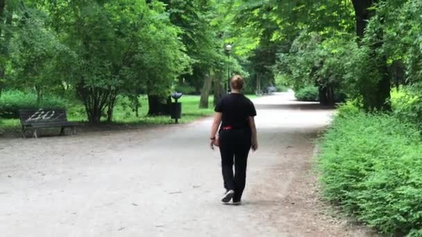 Mujer de tamaño caminando en el parque de primavera — Vídeos de Stock