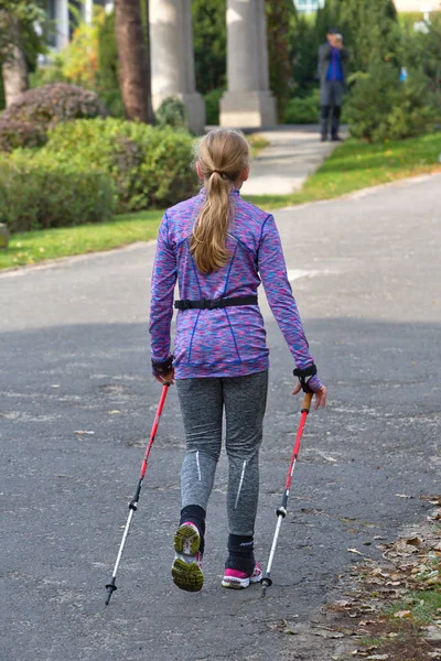 Jonge vrouw in nordic walking-race op straat. — Stockfoto